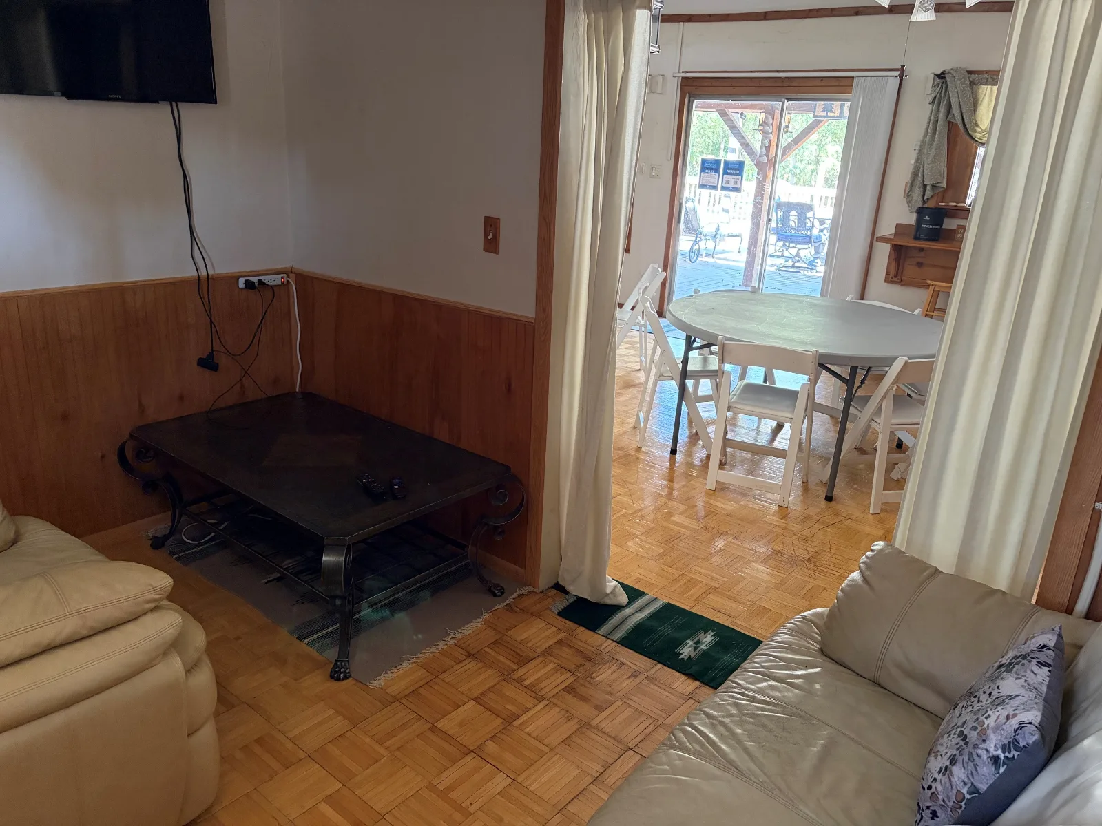 The guest lounge with couches, a pool table and a TV
