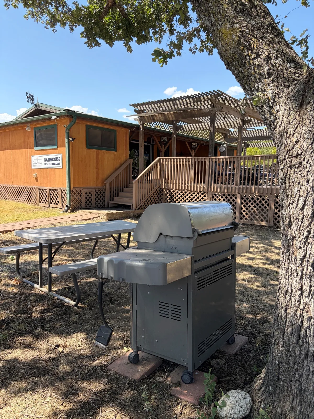 The shared grill and picnic table beside the bathhouse