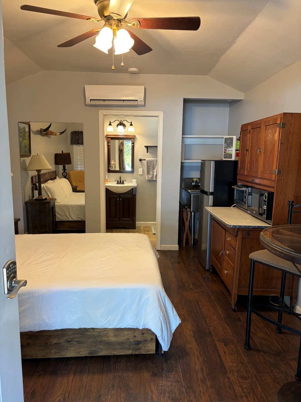 Inside Cabin 1 at Waterfront Hideaway Ranch — a queen bed and kitchenette in one open room with a wood floor