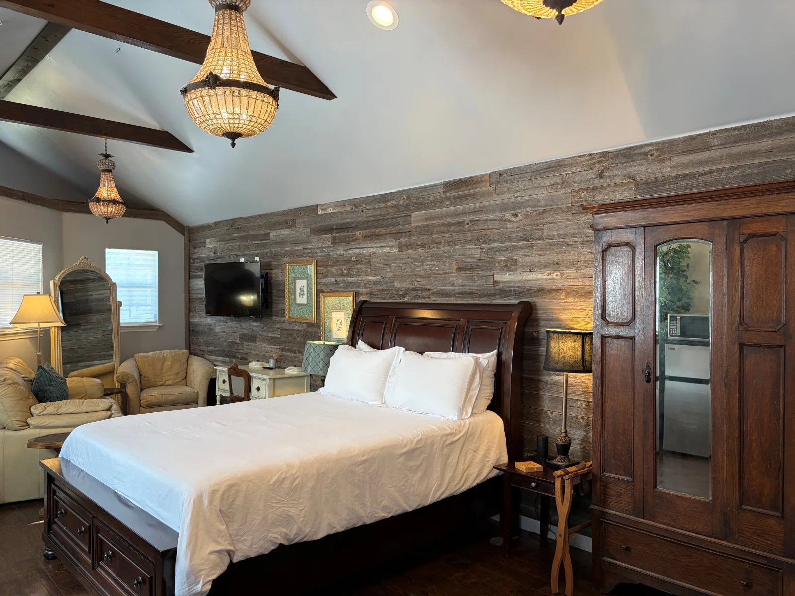 Inside Cabin 2 at Waterfront Hideaway Ranch — a queen bed under exposed beams with a wood accent wall